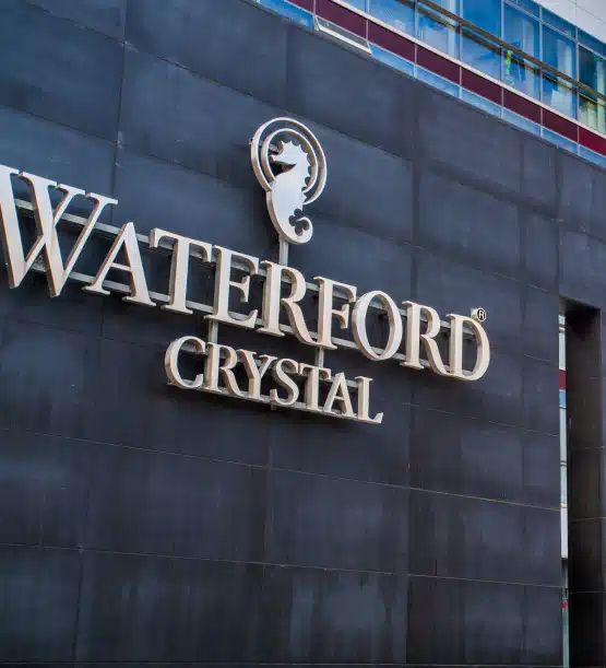 A highlight of any Southern Ireland highlights tour, the large "WATERFORD CRYSTAL" sign with its seahorse logo stands out on the dark tiled exterior wall of this modern building.