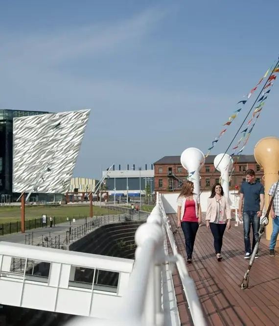 A group of people walking on a decking.